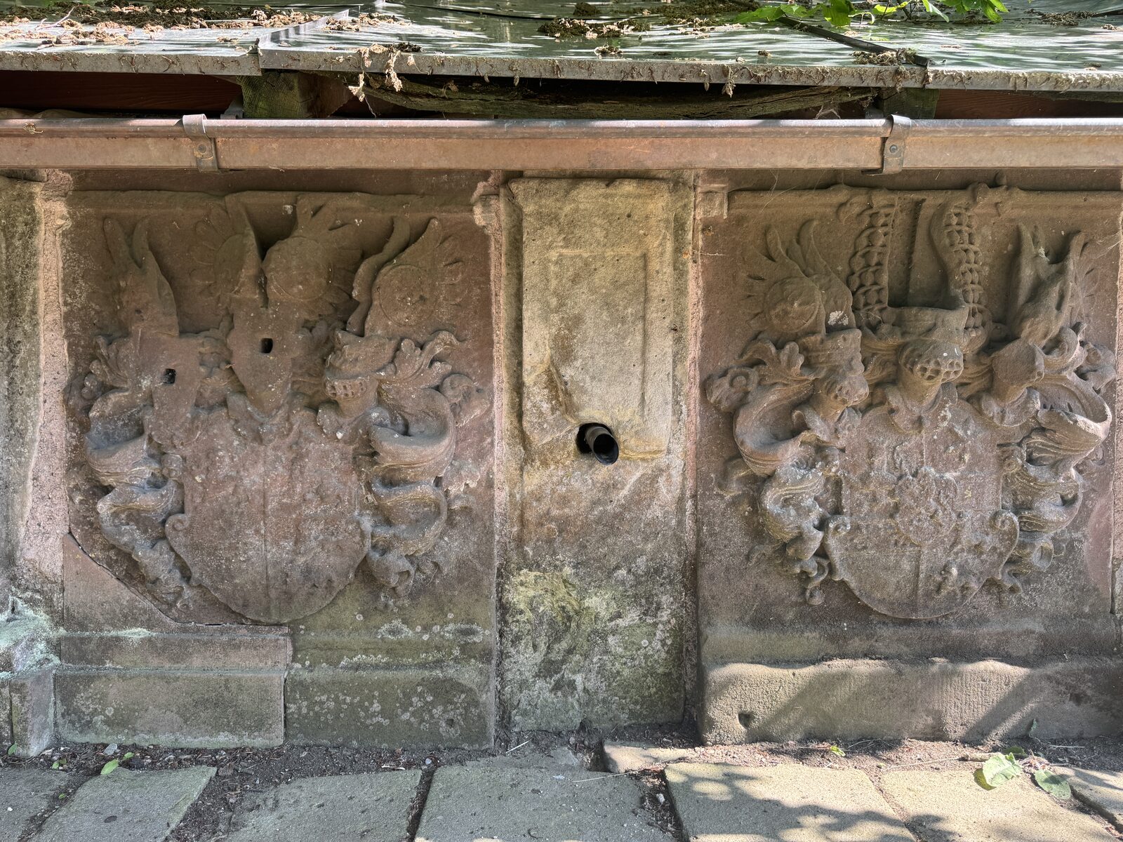 Steinernes Wappenrelief unter der Dachtraufe